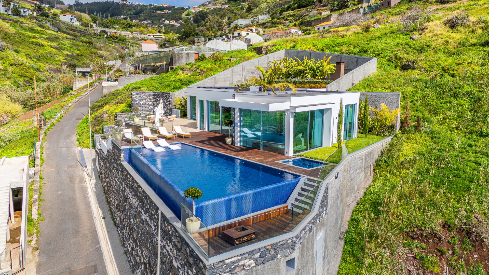 Vista aérea de moradia contemporânea na Madeira com piscina infinita sobre o mar